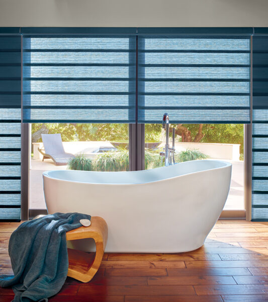 bohemian bathroom with stand alone tub and hunter douglas vignette modern roman shades on large window Reno