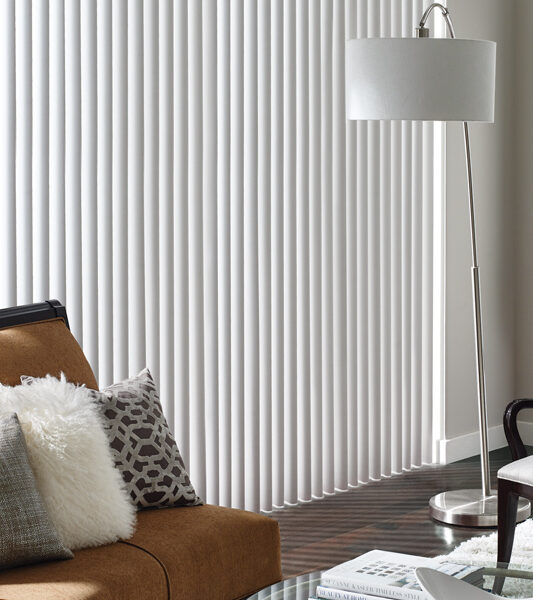 modern living room with brown velvet sofa and cadence soft vertical blinds on sliding glass door by Hunter Douglas Reno