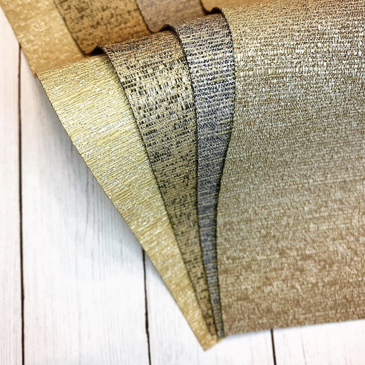 Metallic gold fabric swatches for window treatments.