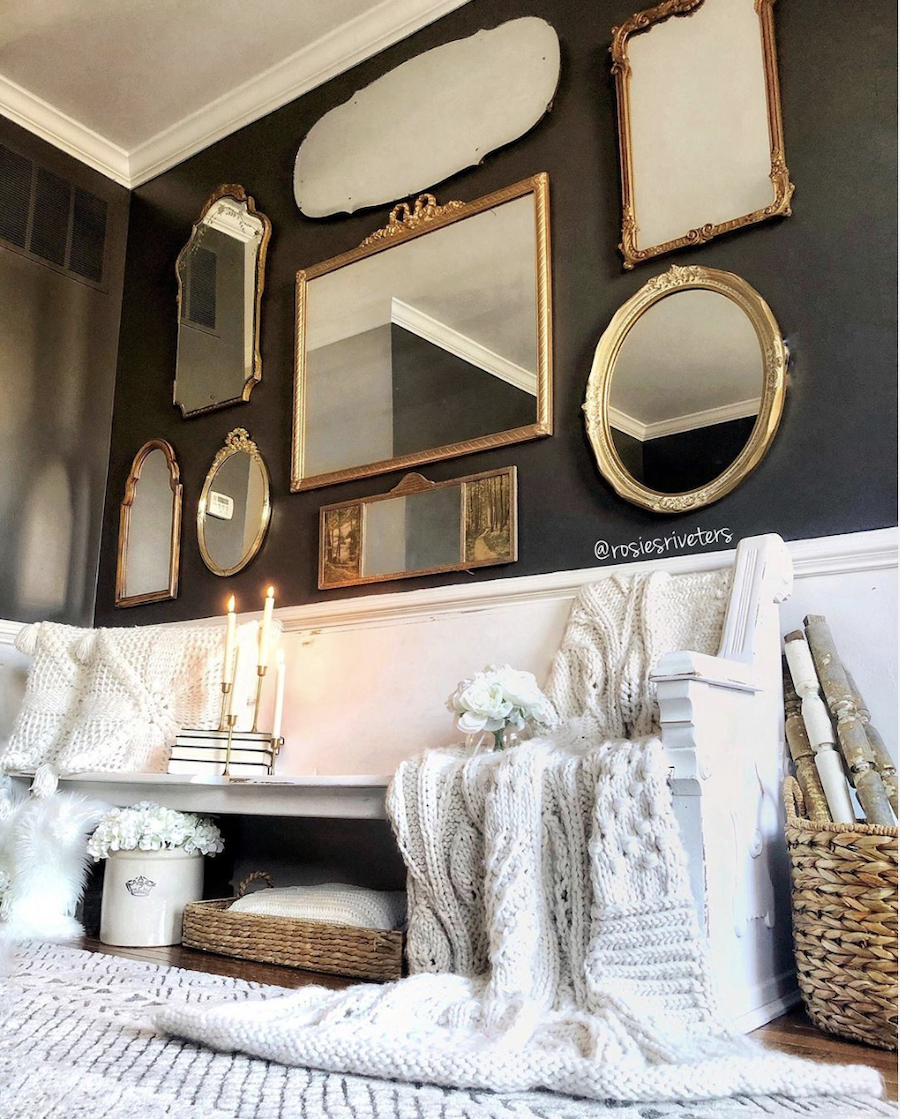 Gold, vintage mirrors on a dark accent wall.