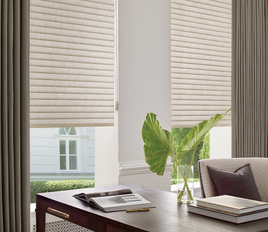 home office with beige cellular roller shades and draperies in Reno NV