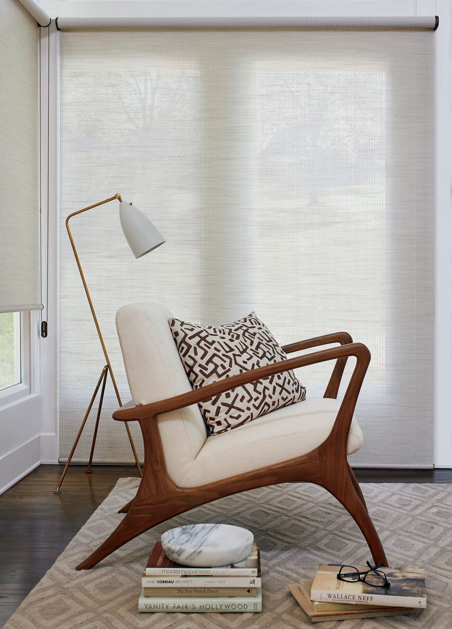 floor to ceiling cream shades next to mid-century modern chair