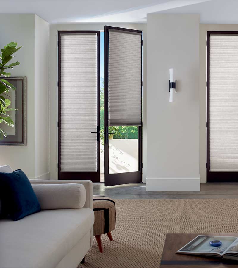 partially open glass door with gray cellular shades in Reno, NV