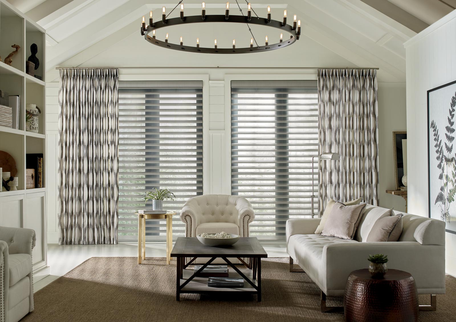 pirouette shades on tall windows in living room with patterned drapery