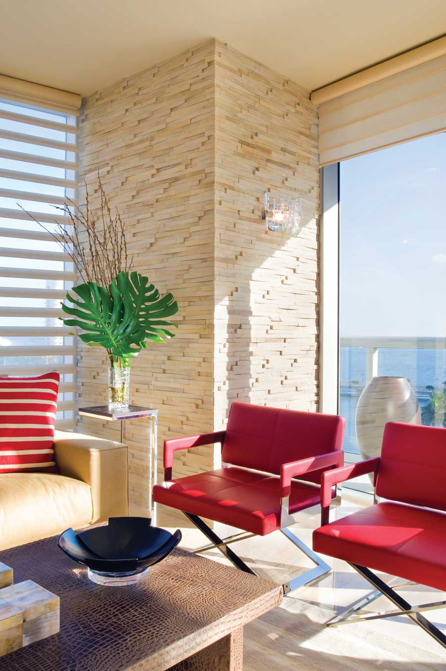 Hunter Douglas Pirouette® Shades in a neutral living room with red chairs and a red pillow.