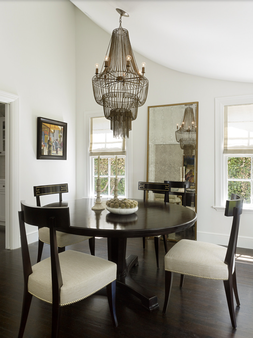 Floor length mirror with two windows on the side in a dining room