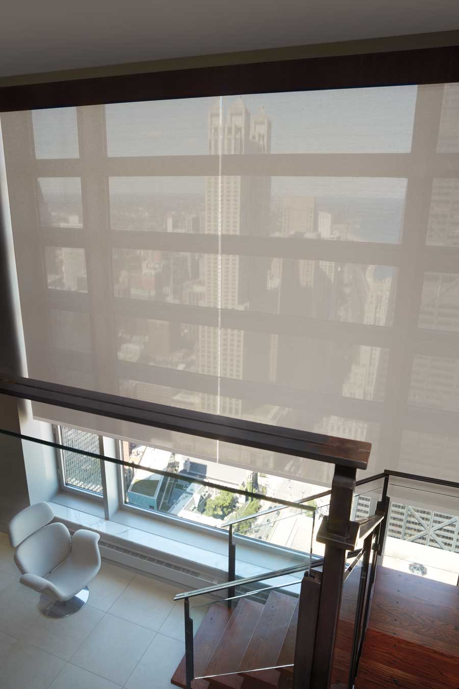 Big windows with designer screen shades blocking out the sun but exposing the view over floor to ceiling windows on the stairs