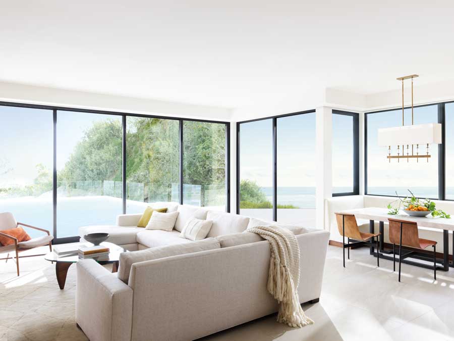 floor to ceiling black trim windows in a living room overlooking a pool area.