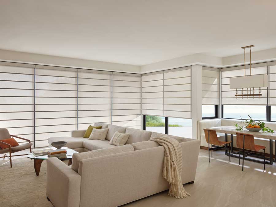 Alustra® Architectural Shades on floor to ceiling windows in a living area.