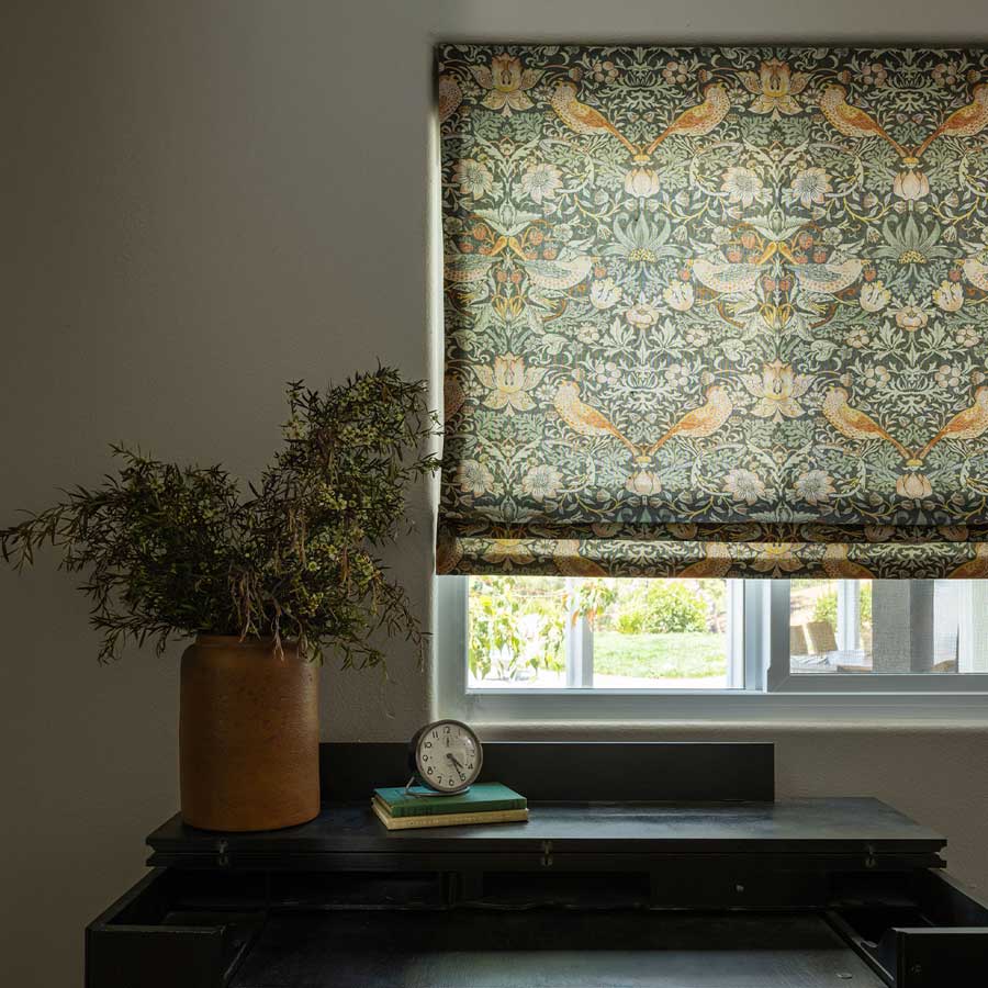 blue and green bird fabric window roman shades next to plant on window