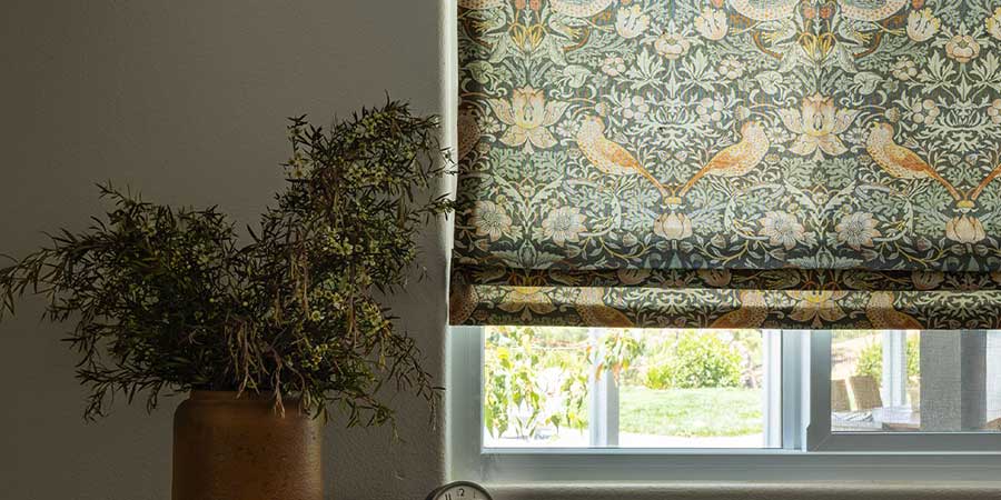 natural whimsical bird patterned window shades next to plant blue sky shutters and shades
