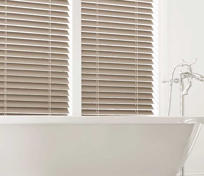 bathroom with tub with brown everwood wood blinds