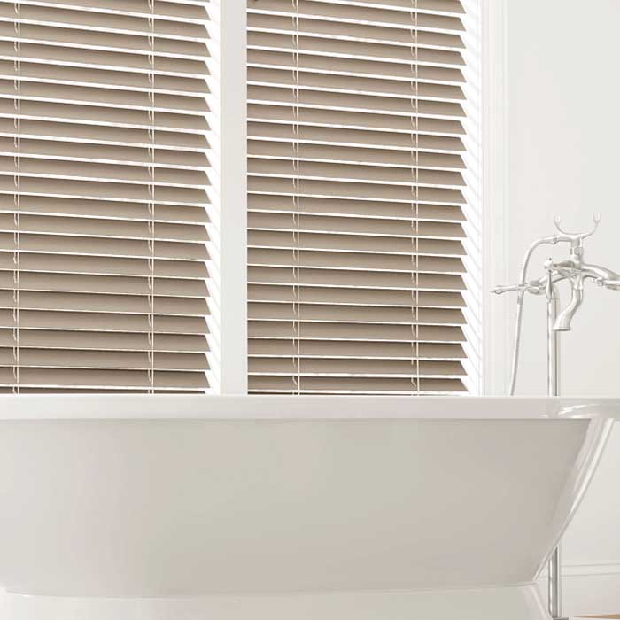 bathroom with tub with brown everwood wood blinds