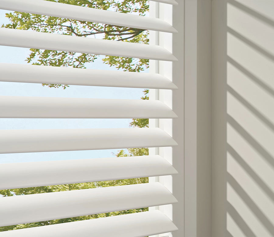 close up of white vinyl shutters on window